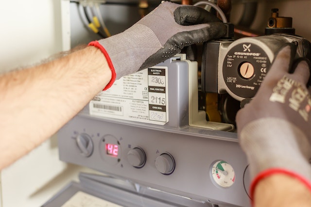 A man in gloves is working on a gas furnace Sydney